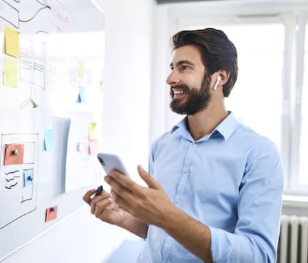 Man working with website wireframes at white board