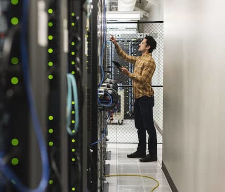 Man inspecting controls in server room
