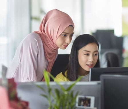 Two women working together on a computer